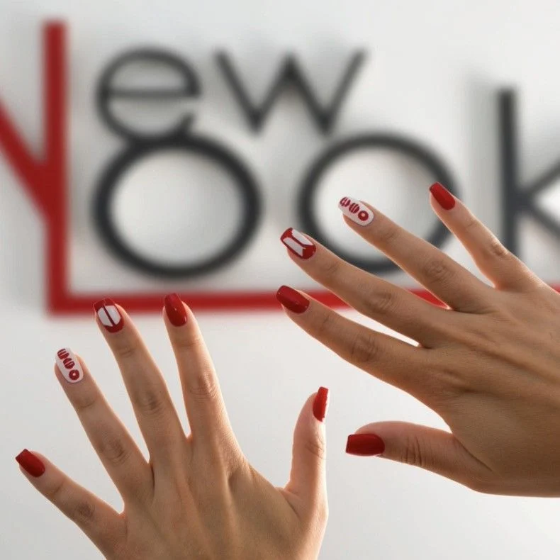 Manicura roja frente al rótulo